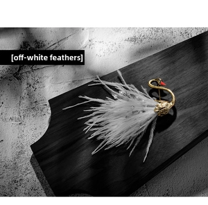 Close-up of elegant swan brooch with creamy white feathers and pearl embellishments