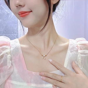 Elegante collana con ciondolo a fiocco in oro rosa e cristallo indossata da modella