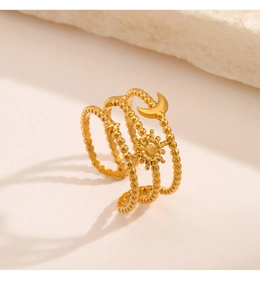 Detailed close-up of triple-layered sun moon and star gold ring on a stone texture surface