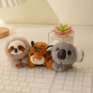Simpatici peluche magnetici con tigre, koala e bradipo su una tastiera bianca
