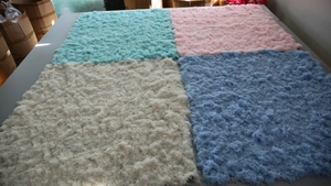 Detailed view of square synthetic moss turf samples in blue, pink, white, and purple