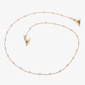 Detail of elegant gold chain with white pearls and metal alligator clips for glasses
