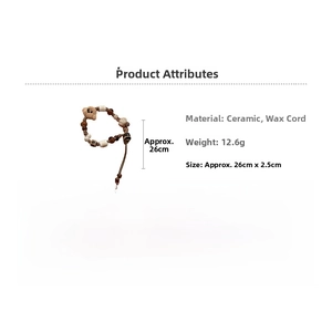 Detailed macro view of woven wax rope bracelet featuring ceramic beads and a brown plush bear