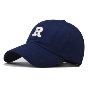 Macro detail of white 3D embroidered letter R on navy blue cotton canvas baseball cap