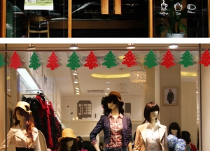 Detail of red and green felt Christmas tree banners hanging in a store window display