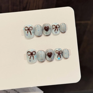 Blue and brown handmade press-on nails with 3D bows, hearts and polka dot designs