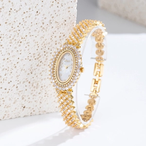 Macro shot of gold oval watch with mother-of-pearl dial and handset zircon stones