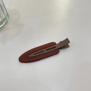 Detail of dark reddish-brown matte jelly hair clip with a metallic spring mechanism