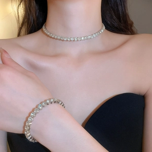 Macro detail of sparkling diamond necklace and bracelet set in silver metal finish