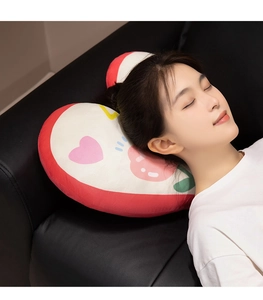 Close-up of heart-shaped plush pillow on leather sofa used as a comfortable nap cushion