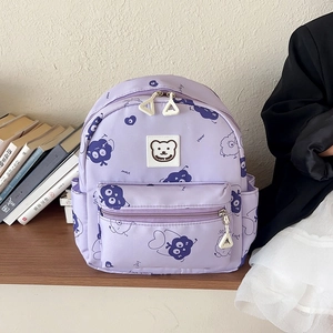 Zaino per bambini viola con stampa di pecorelle e nuvole in un ambiente interno accogliente