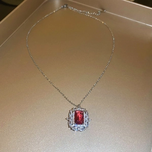Dettaglio del ciondolo vintage con zircone rosso taglio smeraldo su catena dorata
