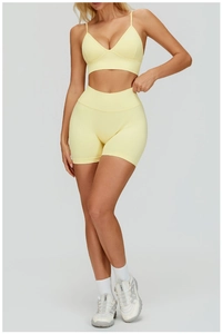 Détail macro de l'ensemble de yoga jaune sans couture avec short taille haute et brassière