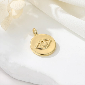 Macro detail of a 14K gold-plated Evil Eye pendant on a luxurious silk background