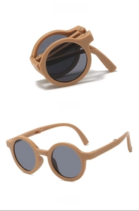 Foldable round kids sunglasses in brown frame with grey lenses showing compact folded state