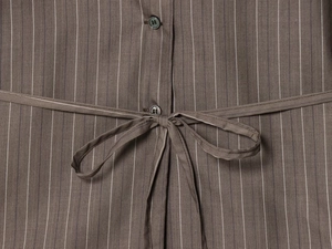 Gros plan sur la taille du costume à rayures avec bouton et ceinture fine assortie