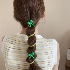 Détail d'un élastique spirale à fleurs vertes pour une queue de cheval élégante
