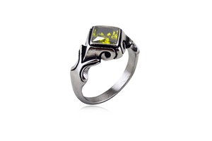 Detail of vintage silver ring featuring a square green gemstone and embossed patterns