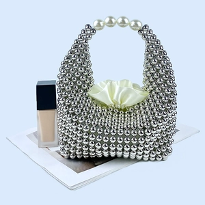 Detail of silver beaded pillow bag featuring pearl handles and satin drawstring lining