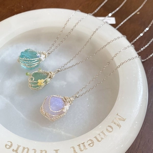 Detail of natural raw stone necklaces in blue, green and purple on marble tray