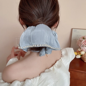 Detailed back view of light blue pleated satin hair scrunchie with white pearl trim
