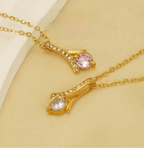 Detail of two stainless steel necklaces featuring pink and white rhinestone pendants