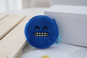 Detail of round plush coin purse in royal blue with embroidered emoji smiling face