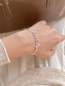 Detail of a 925 sterling silver beaded bracelet worn on a wrist with a lifestyle backdrop