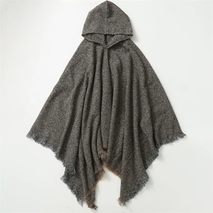 Detail view of brown and grey tweed poncho featuring textured boucle yarn and tassel trim