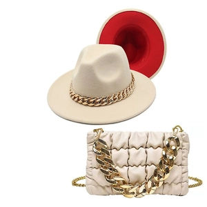 Detail of beige wool fedora with red contrast brim and matching pleated chain handbag
