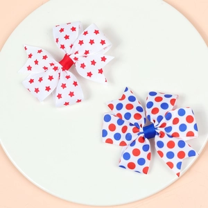 Independence Day hair clips with star and polka dot patterns on a white display tray