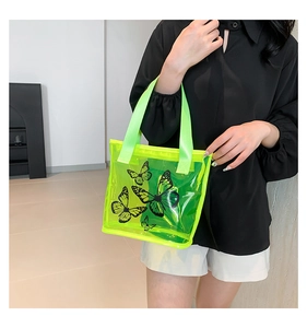Detail of neon green transparent PVC tote bag with black butterfly prints and handles