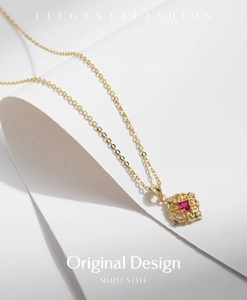 Detail of s925 silver necklace featuring a red square gemstone in a gold hollow pendant