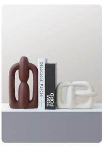 Detail of modern abstract ceramic vases with hollow geometric frames and matte finish