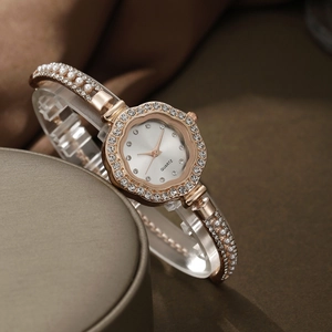 Detailed macro view of gold-tone floral quartz watch bezel set with sparkling rhinestones