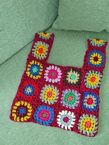 Close-up of handmade crochet tote bag with colorful floral granny square patterns