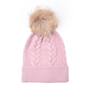Pale pink knit beanie with cable pattern and fluffy faux fur pompom on white background