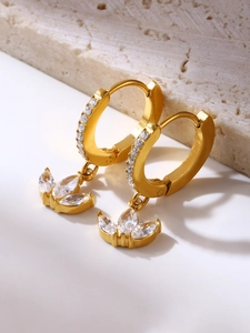 Macro view of gold clover earrings with micro-pave crystals and zircon petals
