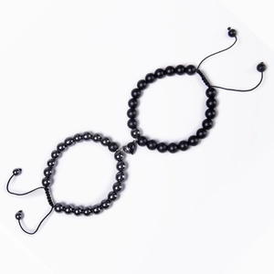 Detail of magnetic heart clasp connecting matte black and gray natural stone bead bracelets