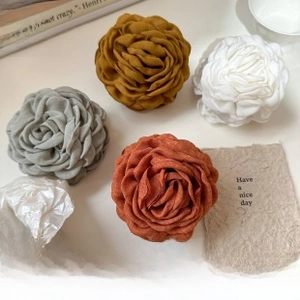 Detailed view of handmade pleated fabric hair scrunchies in four warm autumn colors