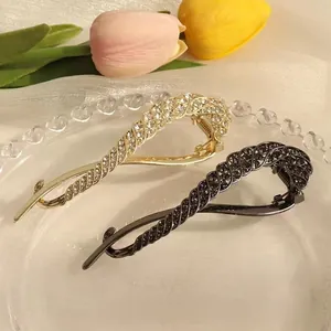Elegant twist hair clip set featuring gold and gunmetal finishes with sparkling rhinestones