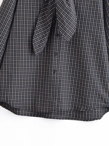 Détail d'une chemise à carreaux style anglais avec col à nouer et tissu texturé fin