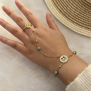 Détail de bracelet bague doré avec perles turquoise et breloque Arbre de Vie