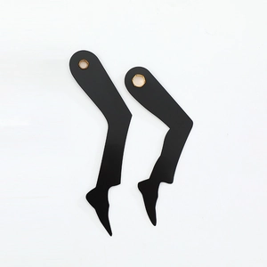 Minimalist black acrylic earrings with female leg silhouette and gold accents