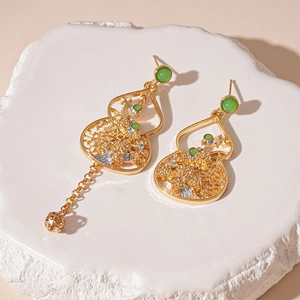 Chinese style hollow gourd earrings with green gems and asymmetrical gold tassels