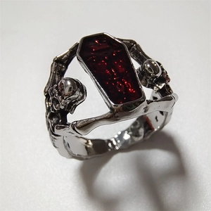 Gothic silver ring with a red coffin-shaped gemstone and detailed skull engravings