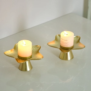 Modern gold star candle holders with white candles for elegant dining table decor