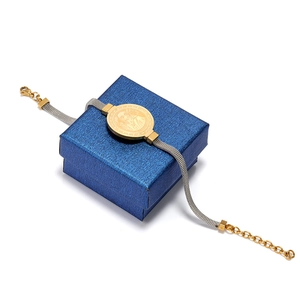 Detail of St. Benedict medal on two-tone stainless steel mesh bracelet with lobster clasp