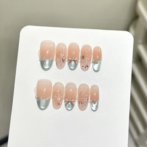 Detail of nude pink cat-eye press-on nails set with 3D bows and silver French tips