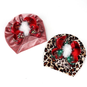Detail of pink velvet and leopard print baby turbans with plaid bows and white pompoms